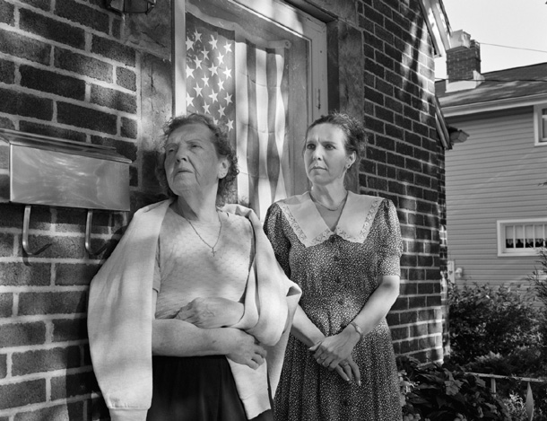 Marjorie Angel with daughter, Rebecca Barile, on Rebecca's front porch with flag