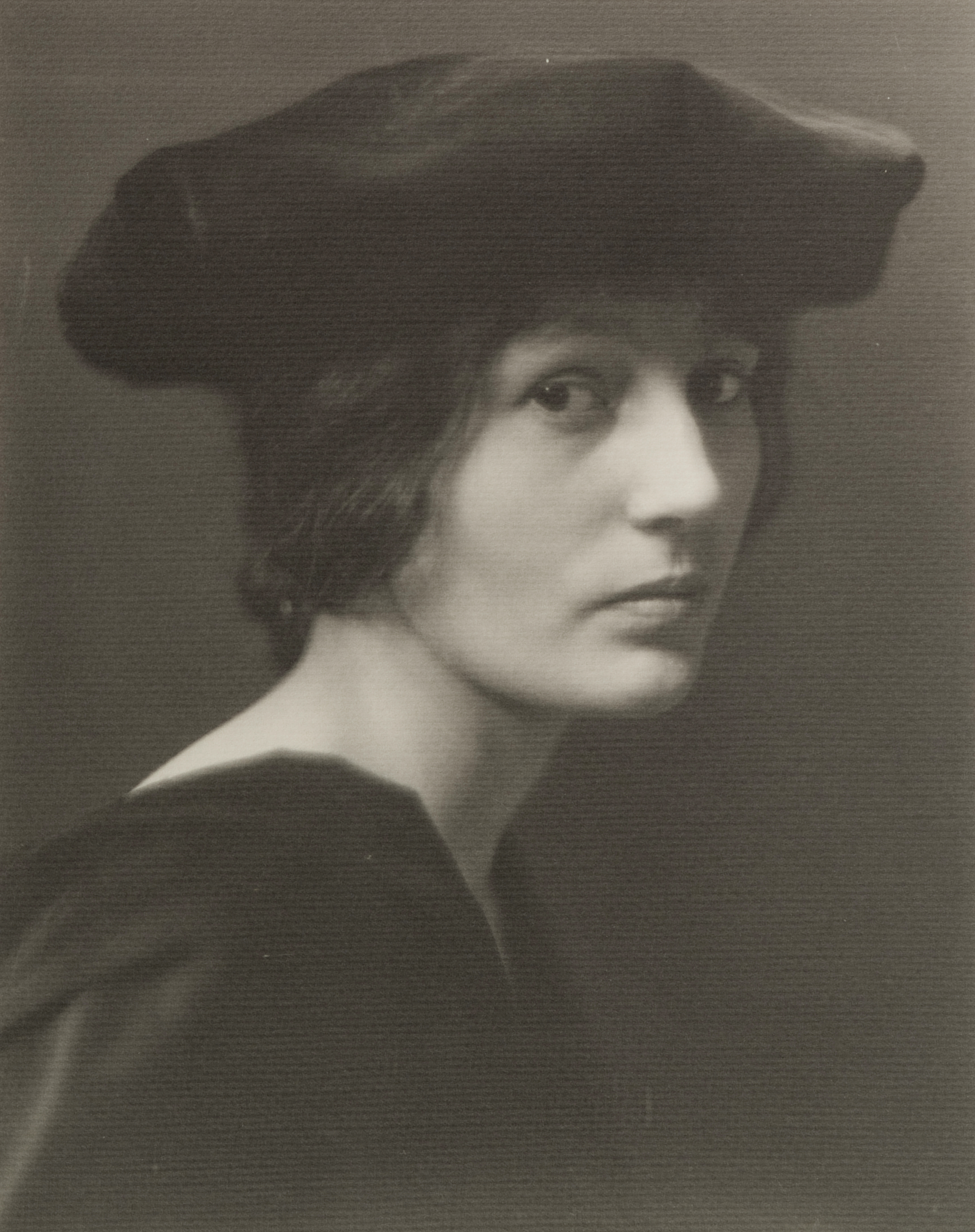 Portrait of a woman in black hat, slouched, view of face and shoulders