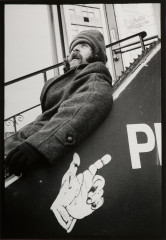 Hip Shots: Man resting on rail of staircase, hand on poster, New York