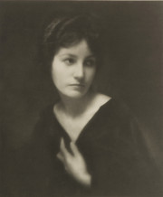 Portrait of a woman in v-necked top, hand at breast, 3/4 view of face
