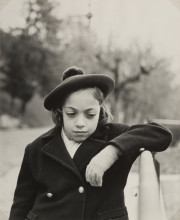 Child in hat and coat, looking down