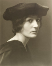 Portrait of a woman in black hat, slouched, 3/4 view of face and shoulders