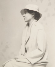 Portrait of seated woman in profile, white coat