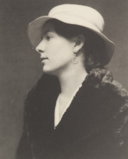 Portrait of woman in profile, with earring, white hat, black coat