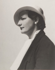 Portrait of woman in profile, white hat, black coat, white scarf