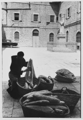 Monk putting bread in bag, Jerusalem, Israel