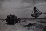Military men riding in a truck on construction site