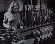 Woman wearing a Leroux uniform making glass bottles