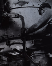 Factory worker adjusting a machine