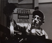 Worker checking fluid level with a flashlight