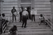 Sheriff Jim Clark arrests two demonstrators who displayed placards on the steps of the federal building in Selma