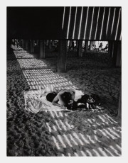 Couple kissing under boardwalk, USA