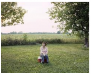 Arathea Booth seated on a cooler in yard smoking a cigarette, Marshallville, Ohio